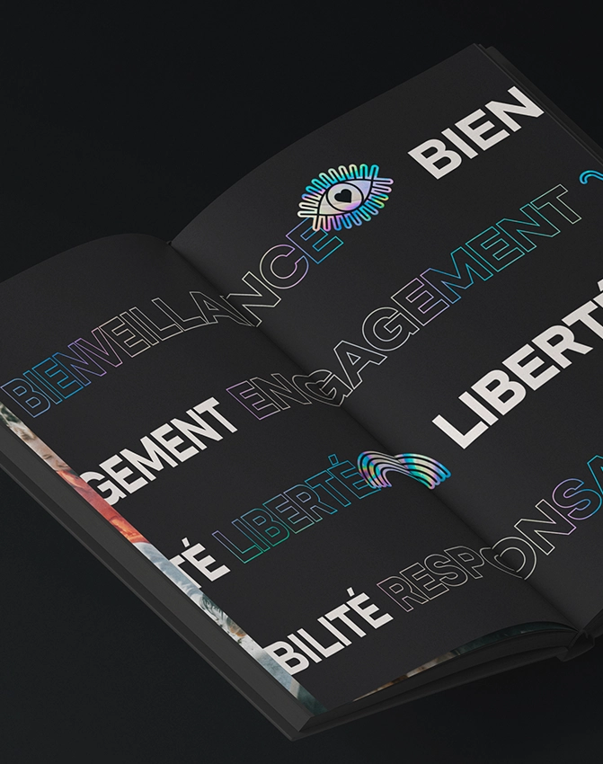 A double-page spread of a book with a black background, featuring bold, colorful, outlined French words like “BIENVEILLANCE,” “ENGAGEMENT,” and “LIBERTÉ,” and graphic eye and rainbow icons.
