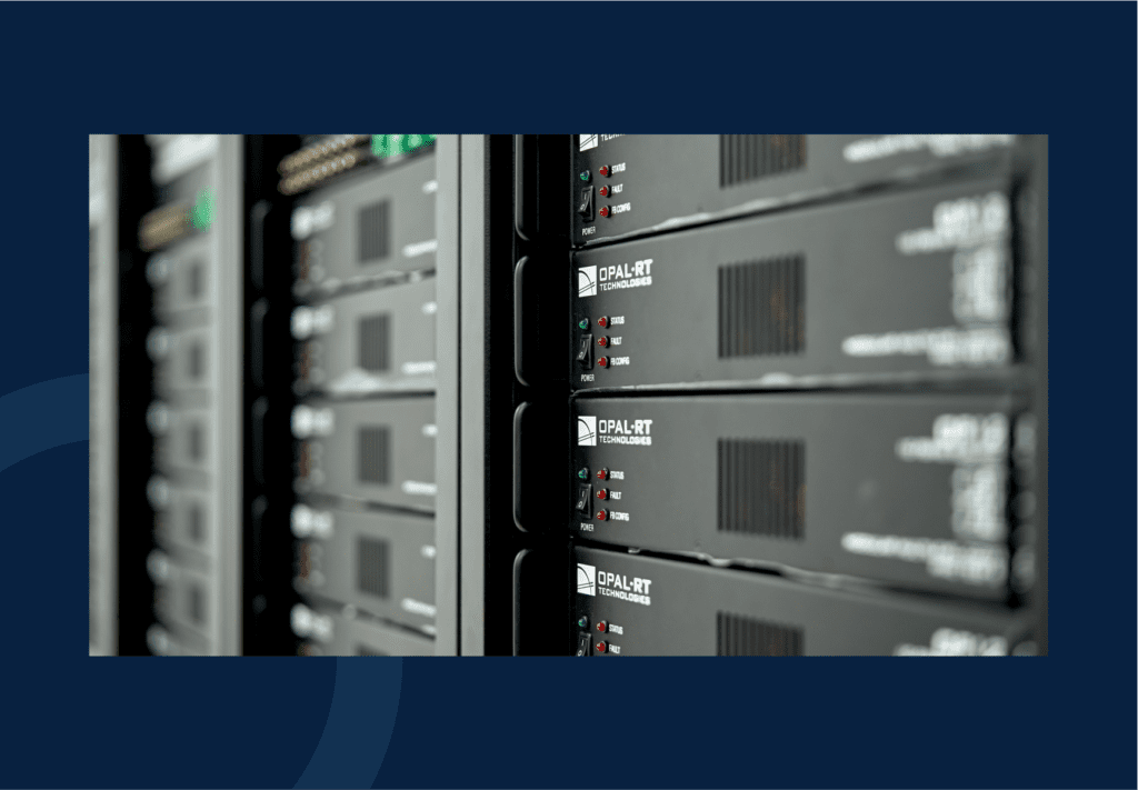 Close-up view of a row of black server racks with indicator lights and IPAL-RT labels in a data center, set against a dark blue background.